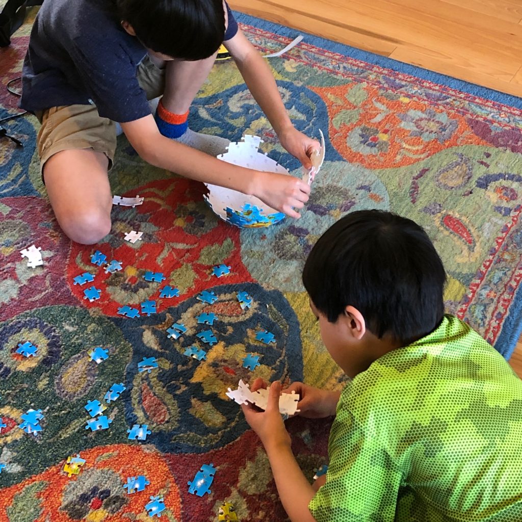 młodzi chłopcy układają puzzle
